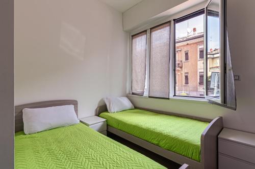 2 letti in una piccola camera con 2 finestre di Cobra apartment Gdarco si trova a 600 mt dalla stazione e metropolitana di Sesto Fs a Sesto San Giovanni