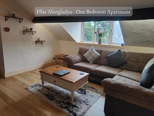 uma sala de estar com um sofá e uma mesa de centro em Llew Accommodation - The Townhouse em Beddgelert