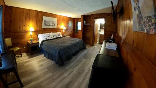 1 dormitorio con 1 cama y suelo de madera en Heart of the Berkshires Motel, en Pittsfield