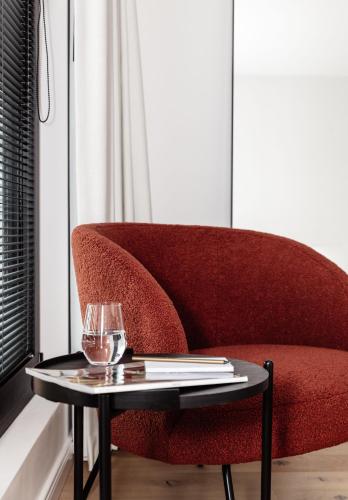 a red couch with a table in a room at CH Longstay 33 in Kortrijk