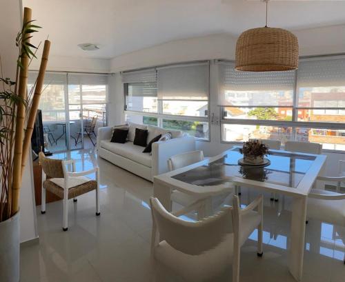 ein Wohnzimmer mit einem weißen Tisch und Stühlen in der Unterkunft Apartamento Van Gogh Dpto 306 in Punta del Este