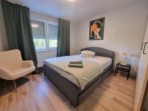 a bedroom with a bed and a chair and a window at Apartament 209 in Alba Iulia