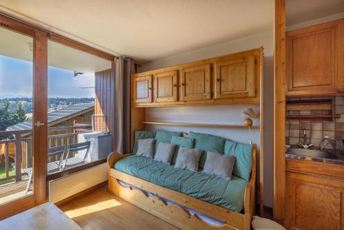 d'un salon avec un canapé et un balcon. dans l'établissement Appartement 2 Pièces - Les Saisies, à Hauteluce