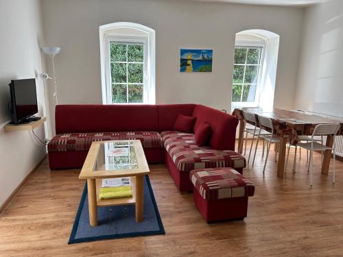 a living room with a red couch and a table at Apartmán v Zahradní in Prachatice