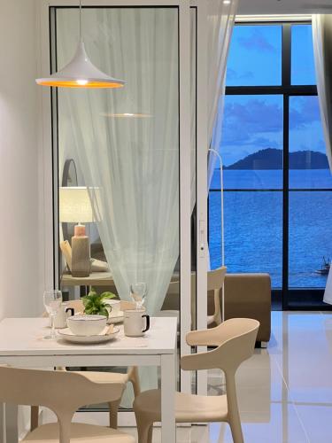 a white dining room with a table and chairs at The Shore CBD Kota Kinabalu By LAXZONE SUITE in Kota Kinabalu