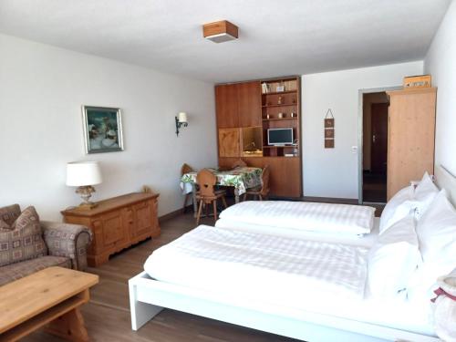 a bedroom with two beds and a couch and a table at Allod Bad 504 in St. Moritz