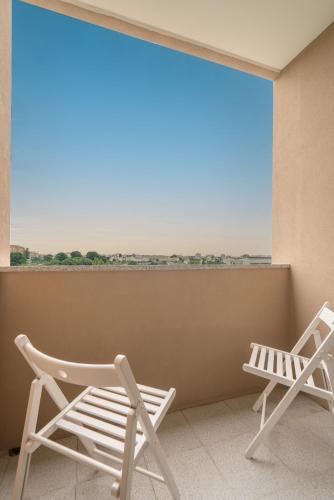 two chairs sitting on a balcony with a large window at Sunny Cozy Flat w/ Terrace - São João in Porto