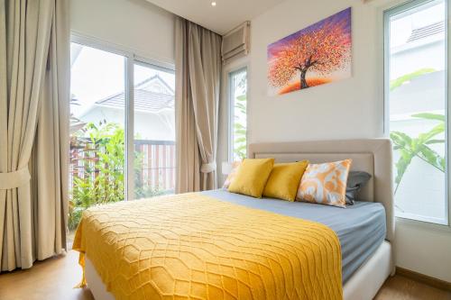 a bedroom with a bed and a painting on the wall at Kamala Garden View Villa 3 Bdr in Kamala Beach