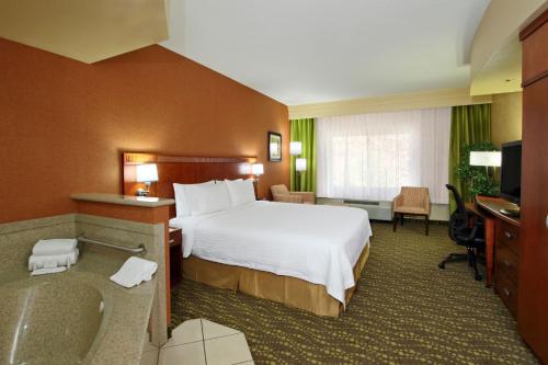 a hotel room with a bed and a bath tub at Courtyard by Marriott St. George in St. George
