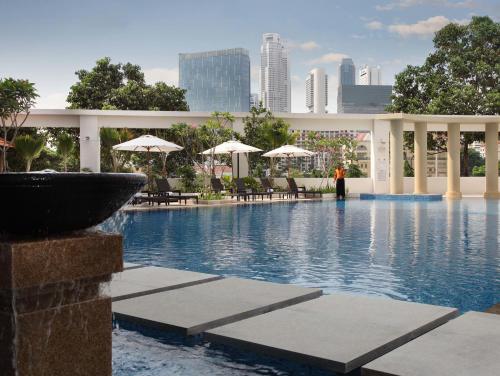 a swimming pool with chairs and umbrellas in a building at The Robertson House by The Crest Collection in Singapore