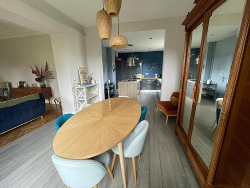 a dining room with a wooden table and chairs at La Maison du Directeur - 224 in Déville-lès-Rouen