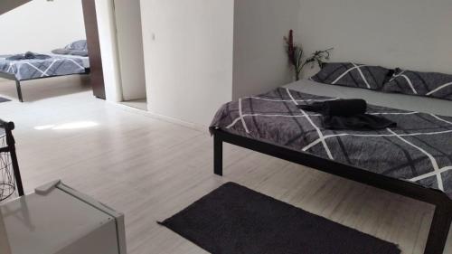 a bedroom with a bed with a black and white comforter at Vila ANA in Cluj-Napoca