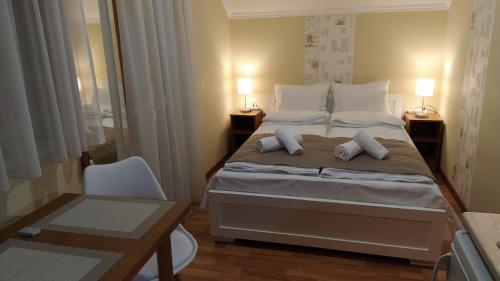 a bedroom with a large bed with two pillows at Gabi & Gabi Apartments in Hajdúszoboszló