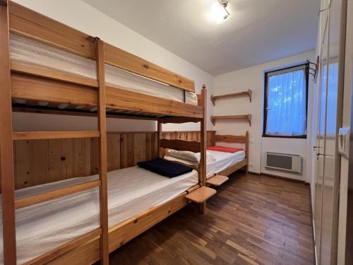 a bedroom with two bunk beds and a window at Trilocale Rendena 035 in Giustino