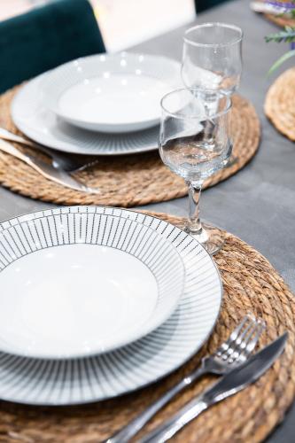 a table set with white plates and glasses and silverware at Valletta Waterfront Backyard Flat by ArcoBnb in Il-Furjana