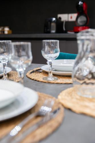 a table with glasses and plates and utensils on it at Valletta Waterfront Backyard Flat by ArcoBnb in Il-Furjana