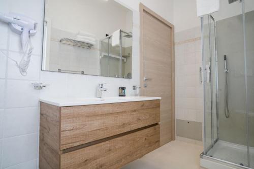 a bathroom with a sink and a shower at La Maison - Boutique Rooms in Sperlonga