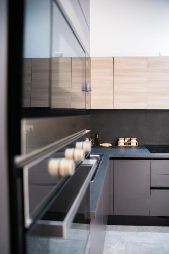 a kitchen with wooden cabinets and an oven at Valletta Waterfront Backyard Flat by ArcoBnb in Il-Furjana