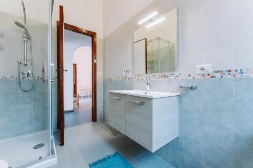 ein Bad mit einem Waschbecken, einer Dusche und einem Spiegel in der Unterkunft Casa Daniela in Terra Mala