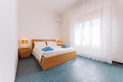 ein weißes Schlafzimmer mit einem Bett und einem Fenster in der Unterkunft Casa Daniela in Terra Mala