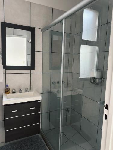a bathroom with a glass shower and a sink at El Mensú Loft in Posadas