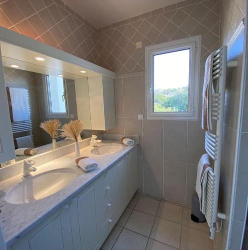 une salle de bain avec deux lavabos et un grand miroir dans l'établissement VILLA A SCOPA 14 VUE PANORAMIQUE MER *, à Pietrosella