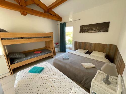 une chambre avec deux lits et un lit superposé dans l'établissement VILLA A SCOPA 14 VUE PANORAMIQUE MER *, à Pietrosella