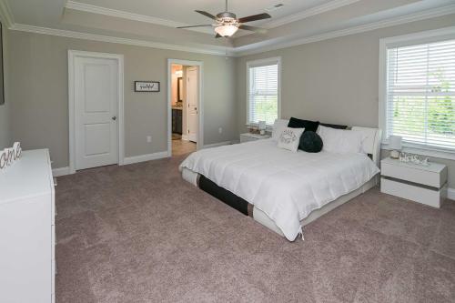 a bedroom with a white bed and a ceiling fan at Quiet Family Home 15 Mi to Dtwn Huntsville! in Hazel Green