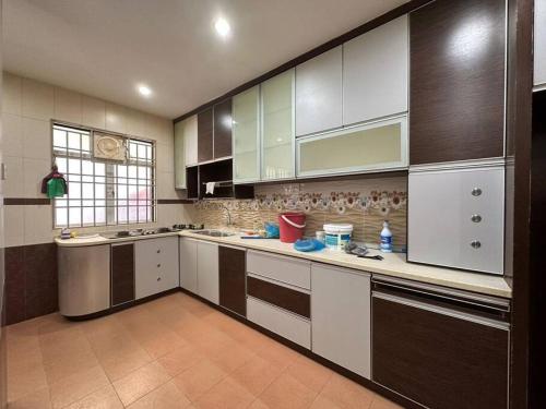 a large kitchen with white and brown cabinets at Muslim Suite Home @ Airport Bayan Lepas Penang in Bayan Lepas