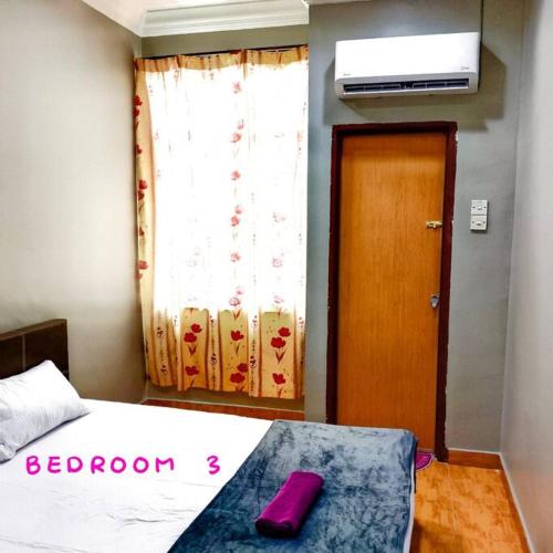a bedroom with a bed with a purple pillow on it at Muslim Suite Home @ Airport Bayan Lepas Penang in Bayan Lepas