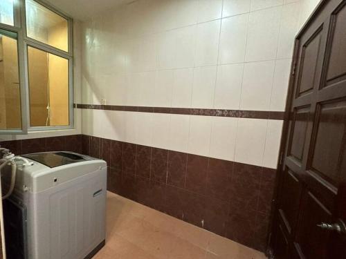 a bathroom with a washing machine and a window at Muslim Suite Home @ Airport Bayan Lepas Penang in Bayan Lepas