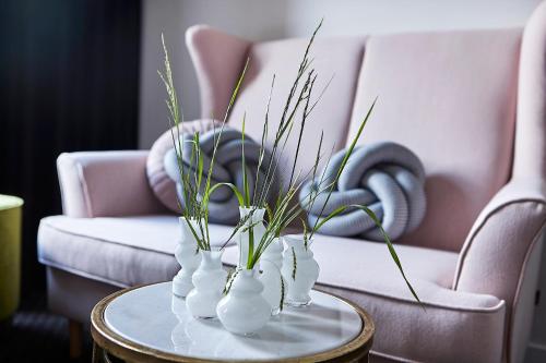 un groupe de vases blancs sur une table avec un canapé dans l'établissement Sielanka, à Ustroń