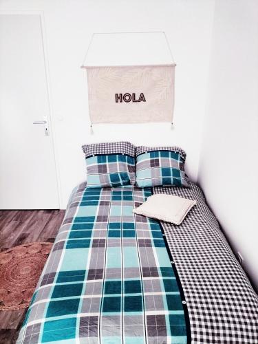 ein Schlafzimmer mit einem Bett mit einer karierten Decke in der Unterkunft Grande Chambre Neuve Parking prive Cergy RER in Cergy