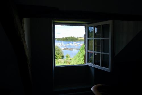 a window in a room with a view of a river at La Grimaudière in La Chapelle-sur-Erdre