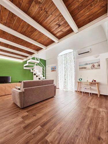 - un salon avec un canapé et des plafonds en bois dans l'établissement Acacia Apartment, à Molfetta
