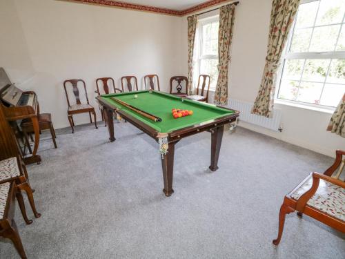 a room with a pool table and chairs at Craiglea Cottage in Coleraine