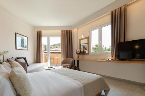 ミティムナにあるAphrodite Hotelのベッドとテレビがあるホテルの部屋