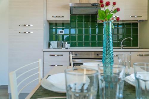 una cucina con tavolo e vaso con fiori di Stella Marina Apartment - Sea View, close to the beach ad Agnone Bagni