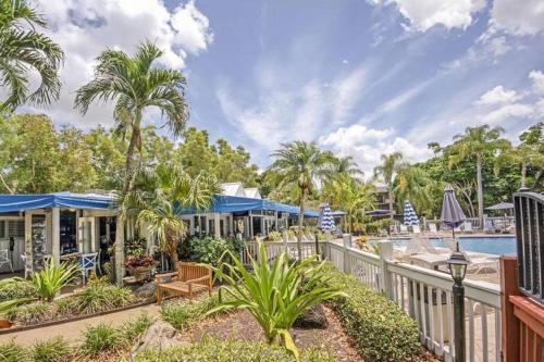 a resort with a pool and palm trees at Park Shore Resort Beautiful Top Floor 2Bed 2Bath in Naples