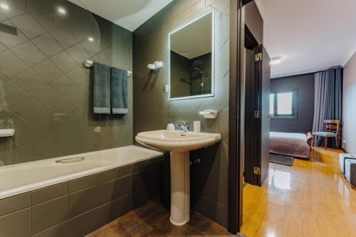 a bathroom with a sink and a bath tub at SUPER Anadia - Golden in Funchal