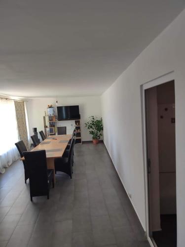 a dining room and living room with a table and chairs at CasaMarinela in Orşova