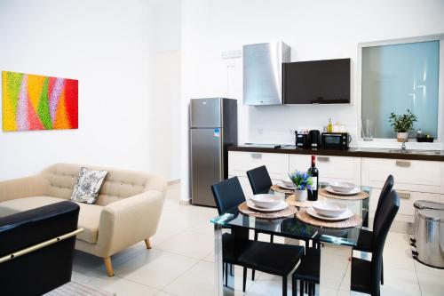 a kitchen and living room with a table and chairs at Valletta Center Apartment by ArcoBnb in Valletta