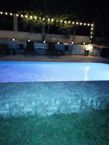 a swimming pool at night with lights around it at CasaMarinela in Orşova