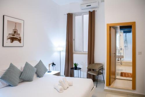um quarto com uma cama branca e vista para a Torre Eiffel em Valletta Center Apartment em Valeta