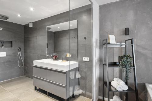 La salle de bains est pourvue d'un lavabo et d'une douche. dans l'établissement Design-Apartment - Bochum Zentrum - 2 Balkons - Wanne - 118m2 - Netflix, à Bochum