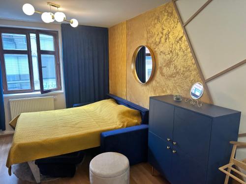 - une chambre avec un lit jaune et un miroir dans l'établissement Apartment Blue House - Old Town, à Bratislava