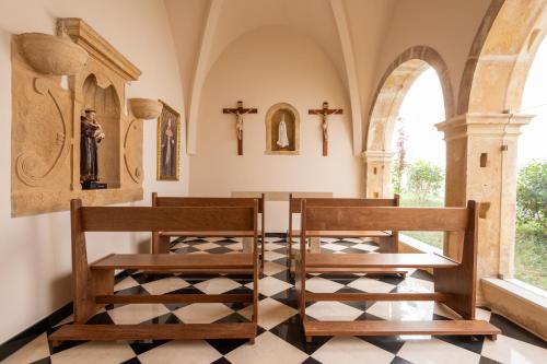 a chapel with two wooden chairs and a table at Vila Gale Collection Tomar in Tomar