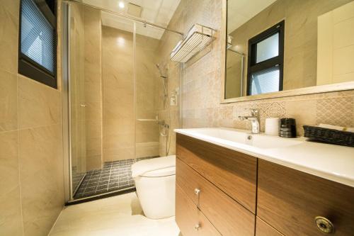 La salle de bains est pourvue de toilettes, d'un lavabo et d'une douche. dans l'établissement 法格洛絲文旅, à Beipu