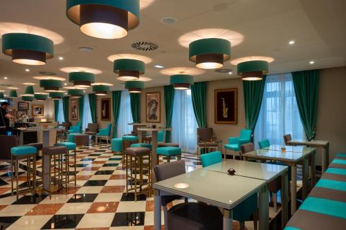 a restaurant with tables and chairs and blue chairs at Vila Gale Collection Tomar in Tomar
