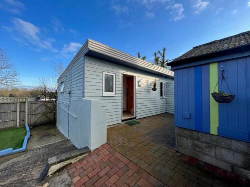 a small house with a colorful shed next to it at Hilltop Farm in Sturminster Newton